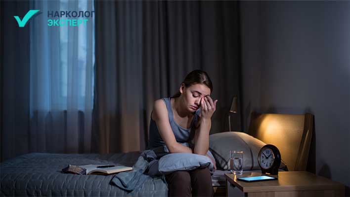 Проблемы со сном Девушка с бессонницей сидит в кровати